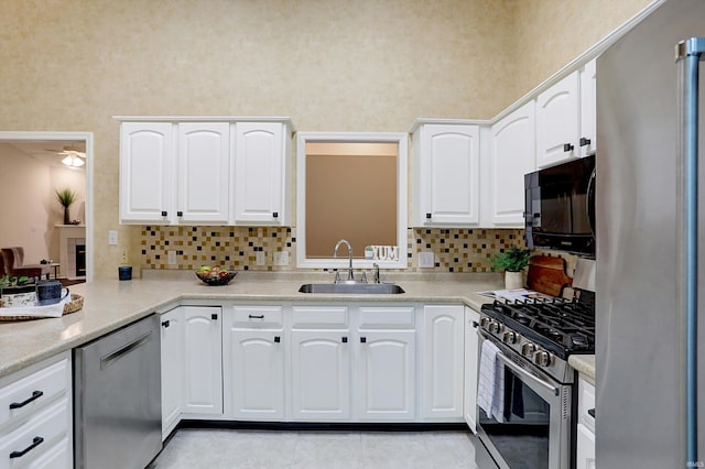 kitchen with backsplash, white cabinetry, sink, and appliances with stainless steel finishes