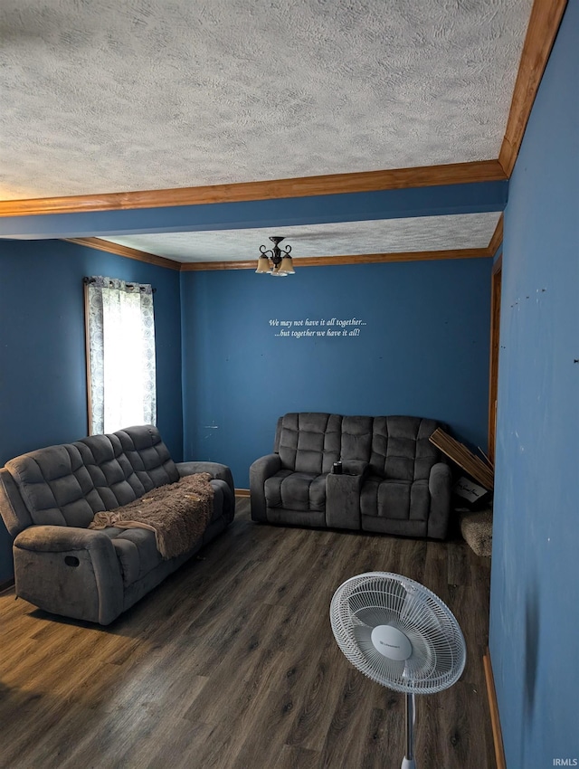 living room featuring crown molding, dark wood-type flooring, and a textured ceiling