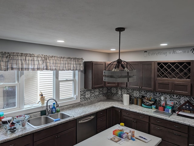 kitchen featuring backsplash, decorative light fixtures, dishwasher, and sink