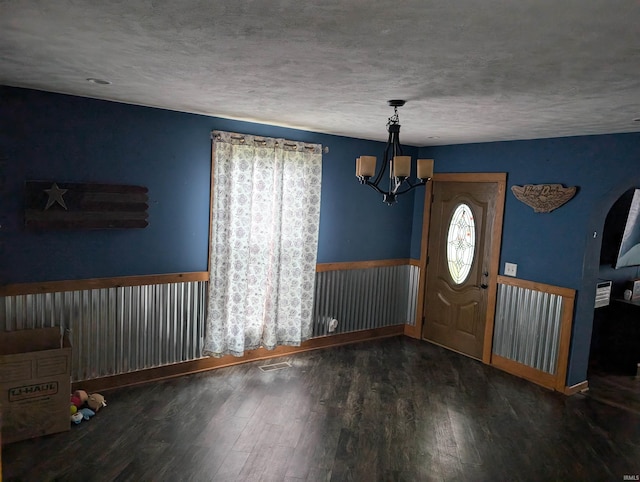 entrance foyer with an inviting chandelier and dark wood-type flooring