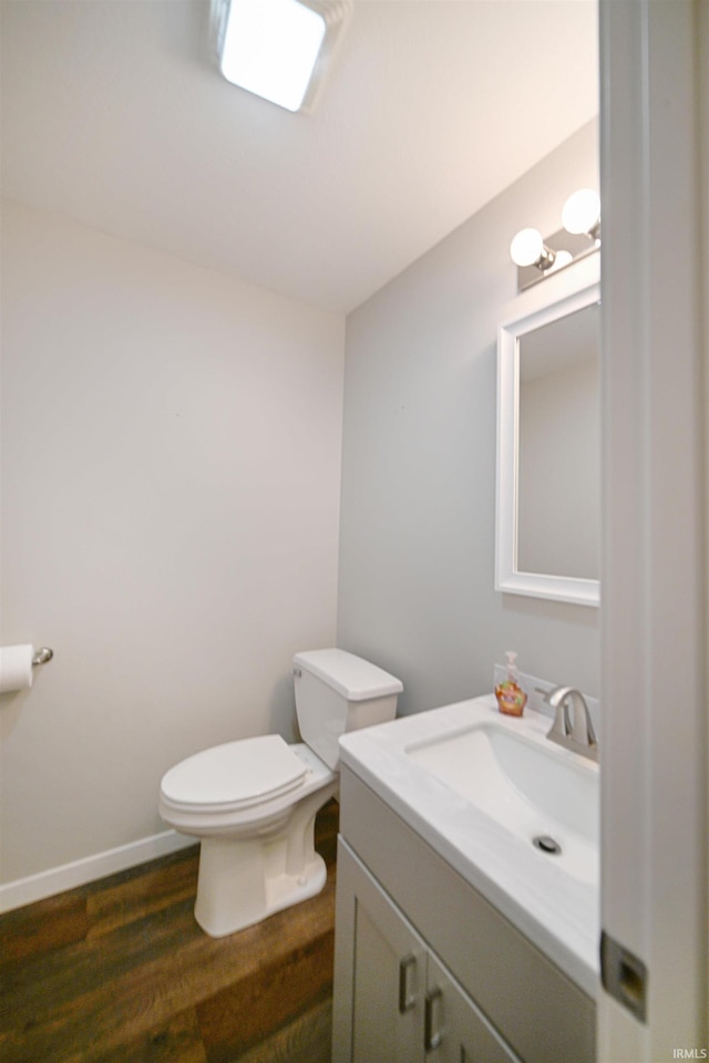 bathroom with hardwood / wood-style flooring, vanity, and toilet