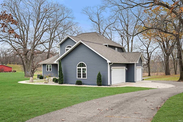 view of side of property featuring a lawn and a garage