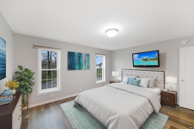 bedroom featuring dark hardwood / wood-style floors and multiple windows