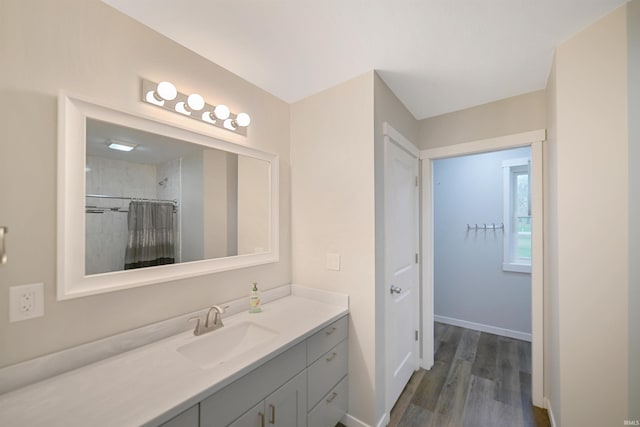 bathroom with wood-type flooring, vanity, and walk in shower