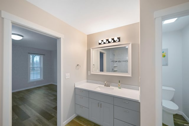 bathroom with toilet, vanity, and hardwood / wood-style flooring