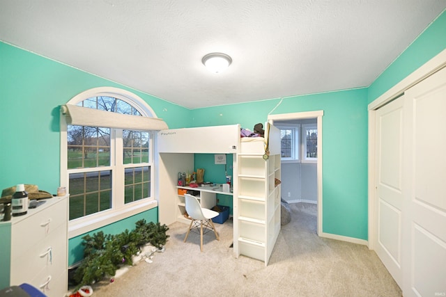 bedroom featuring light colored carpet and a textured ceiling