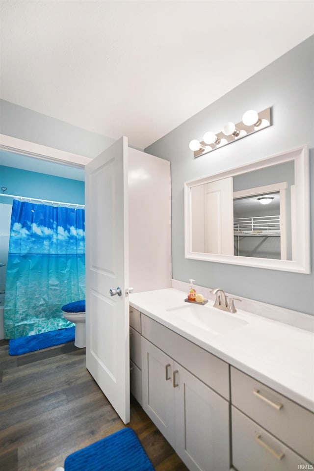 bathroom with vanity, hardwood / wood-style flooring, toilet, and curtained shower