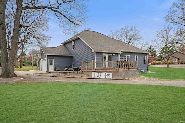 rear view of property featuring a yard, a deck, and a garage