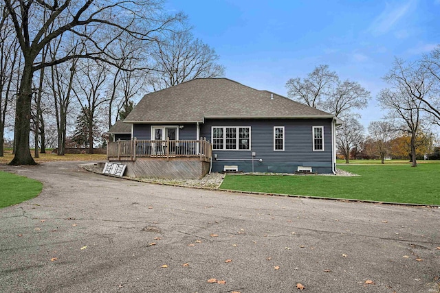 back of property with a yard and a deck