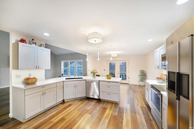 kitchen with white cabinetry, sink, kitchen peninsula, and stainless steel appliances