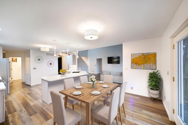 dining room featuring hardwood / wood-style floors and sink