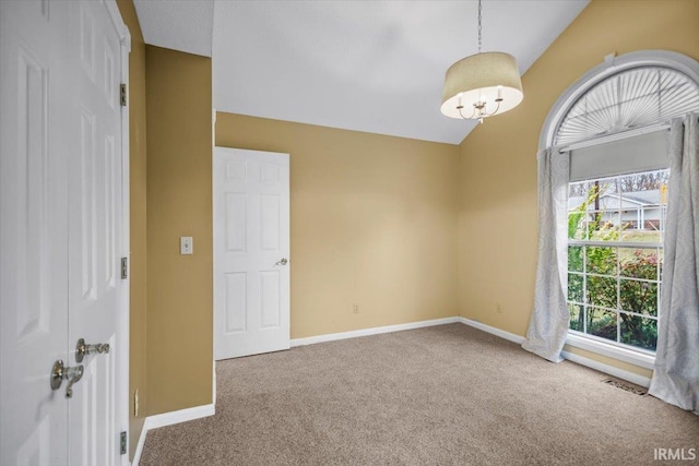 carpeted spare room featuring lofted ceiling