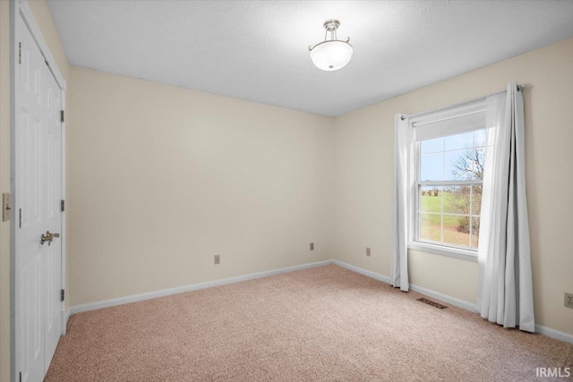 carpeted spare room with a textured ceiling