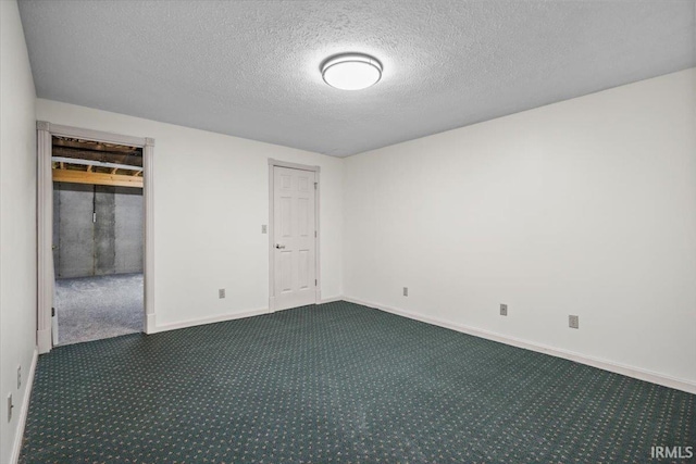 empty room with dark colored carpet and a textured ceiling