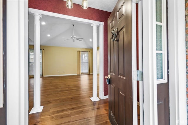 foyer entrance with decorative columns, ceiling fan, dark hardwood / wood-style floors, and lofted ceiling