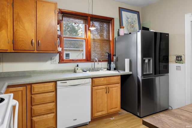 kitchen with light hardwood / wood-style flooring, hanging light fixtures, white appliances, and sink