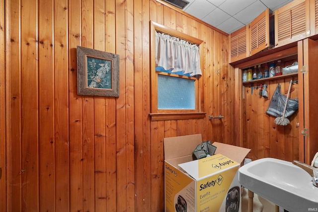 bathroom featuring wood walls and sink