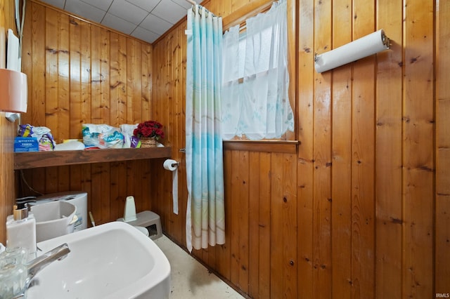 bathroom with sink and wood walls