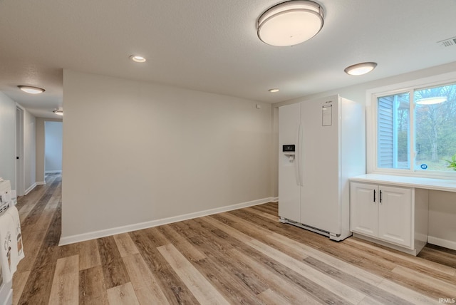 interior space featuring a textured ceiling and light hardwood / wood-style flooring