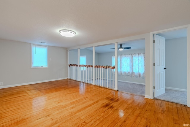 spare room with ceiling fan, wood-type flooring, and a textured ceiling