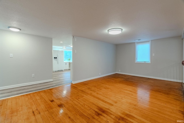 spare room featuring hardwood / wood-style flooring and a textured ceiling