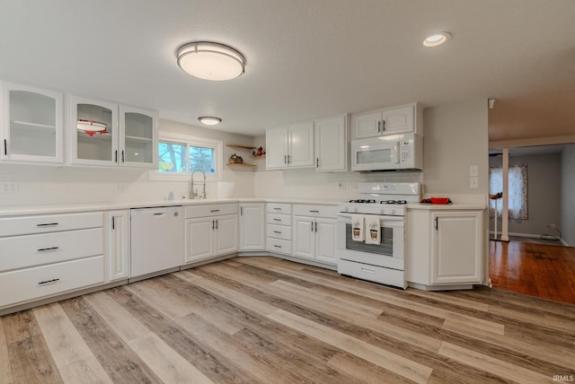 kitchen featuring light hardwood / wood-style flooring, white cabinets, white appliances, and sink