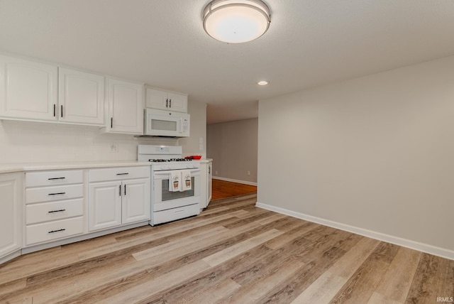 kitchen featuring white cabinetry, light hardwood / wood-style flooring, and white appliances