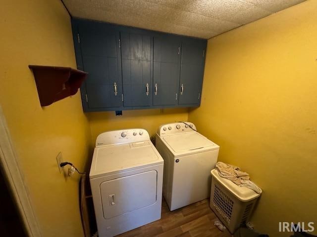 laundry area with washer and clothes dryer, dark hardwood / wood-style flooring, and cabinets