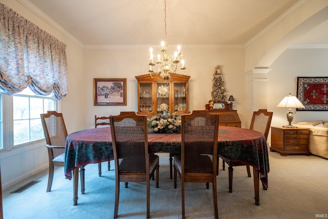 carpeted dining area featuring an inviting chandelier, ornate columns, and ornamental molding