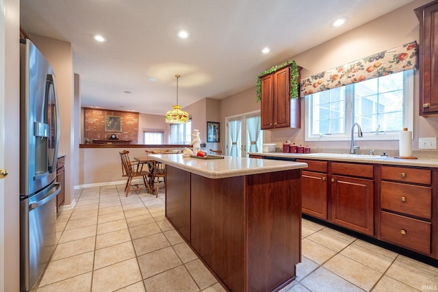 kitchen featuring pendant lighting, a center island, a kitchen breakfast bar, sink, and stainless steel fridge with ice dispenser