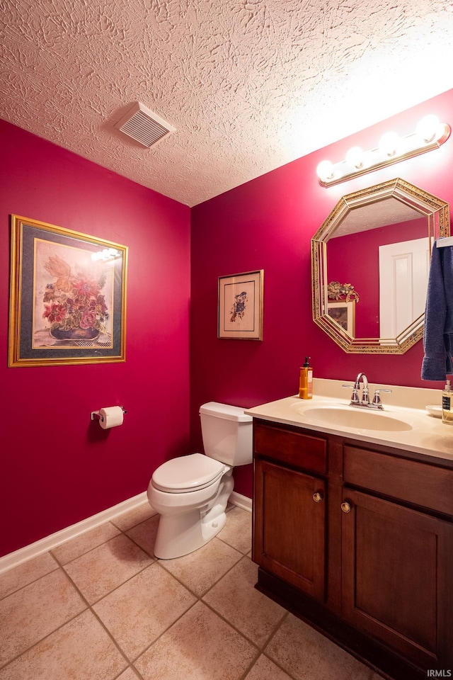 bathroom featuring tile patterned flooring, vanity, a textured ceiling, and toilet