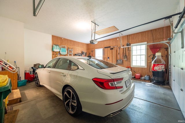 garage with wooden walls and a garage door opener