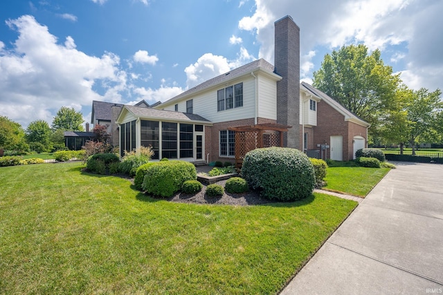 rear view of house with a sunroom, a garage, and a lawn