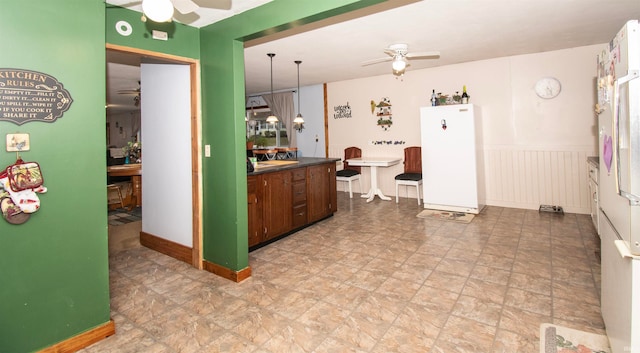 kitchen with decorative light fixtures, white fridge, and ceiling fan