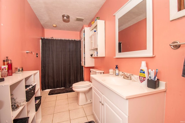 bathroom with tile patterned flooring, vanity, toilet, and a textured ceiling