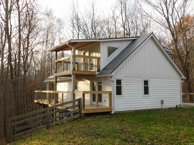 back of house featuring a yard, a balcony, and a wooden deck