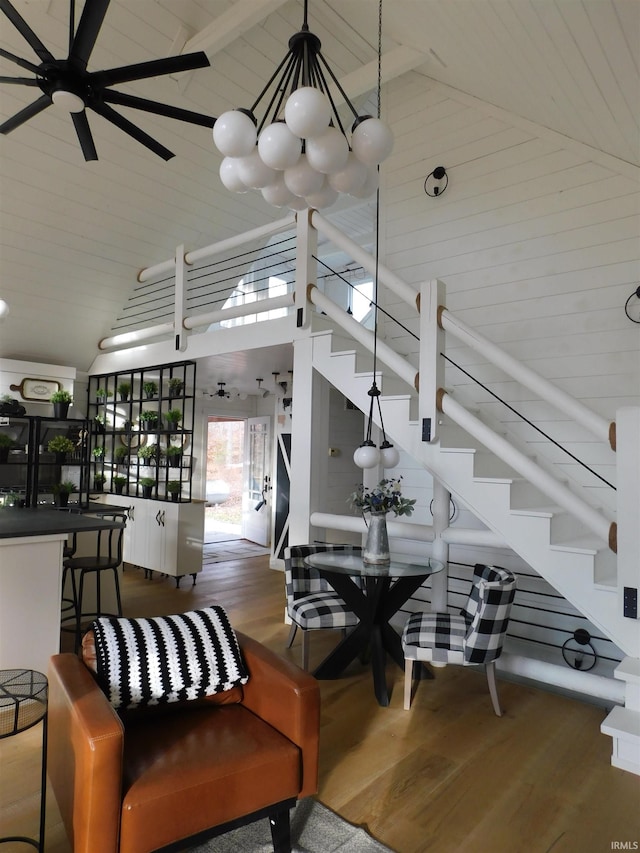 living room with hardwood / wood-style flooring, high vaulted ceiling, and wood walls