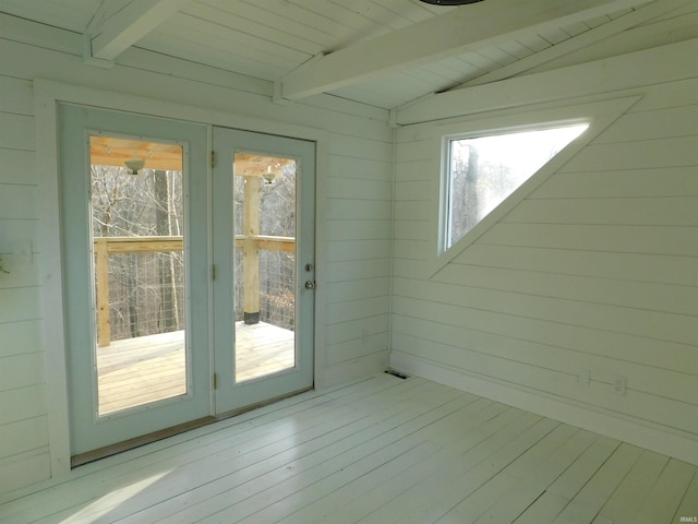 doorway with vaulted ceiling with beams, light hardwood / wood-style floors, wooden walls, and wood ceiling