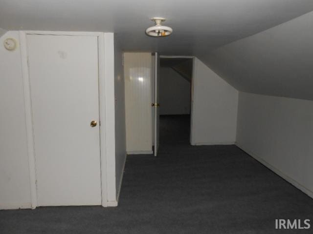 bonus room featuring dark carpet and lofted ceiling