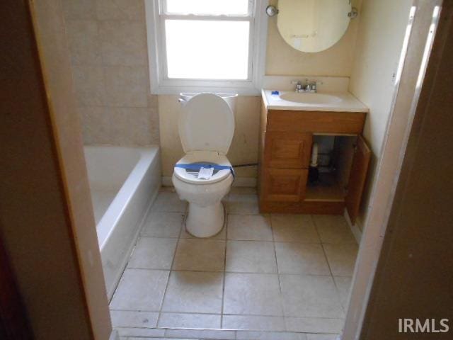 bathroom with toilet, vanity, tile patterned floors, and a bathing tub