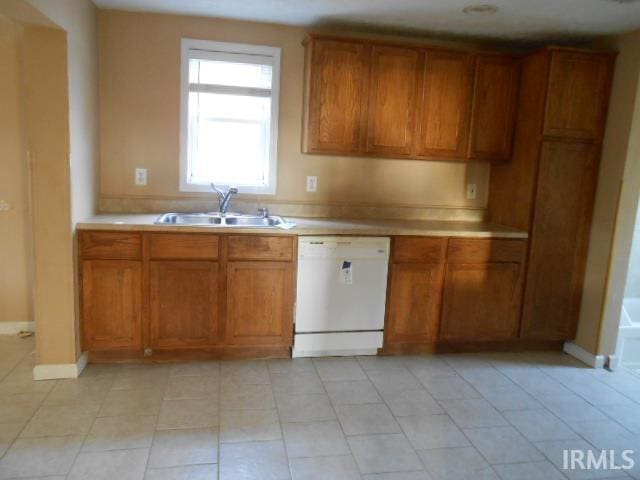 kitchen with sink, white dishwasher, and light tile patterned floors