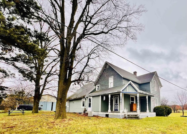 view of front of home featuring covered porch, central AC, a front lawn, and a chimney