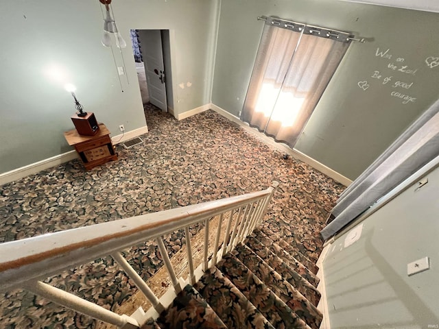 stairway featuring carpet and baseboards