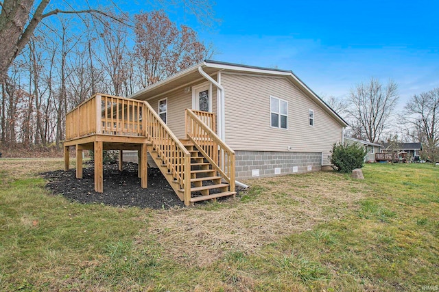 view of side of home with stairs, a yard, and a wooden deck