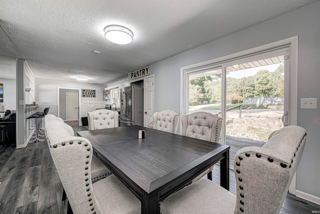 dining room featuring dark hardwood / wood-style flooring and a textured ceiling