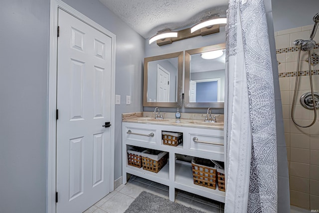 bathroom featuring a tile shower, tile patterned flooring, vanity, and a textured ceiling