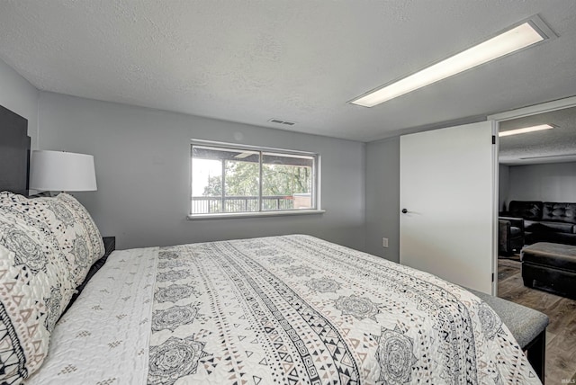 bedroom featuring hardwood / wood-style floors and a textured ceiling