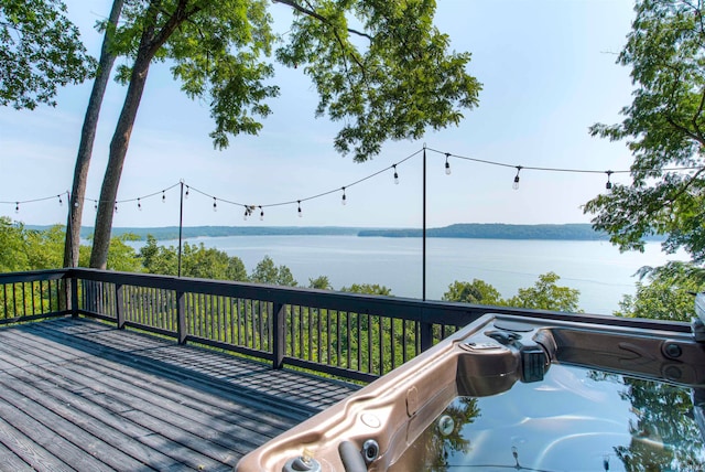 wooden terrace featuring a water view and a hot tub