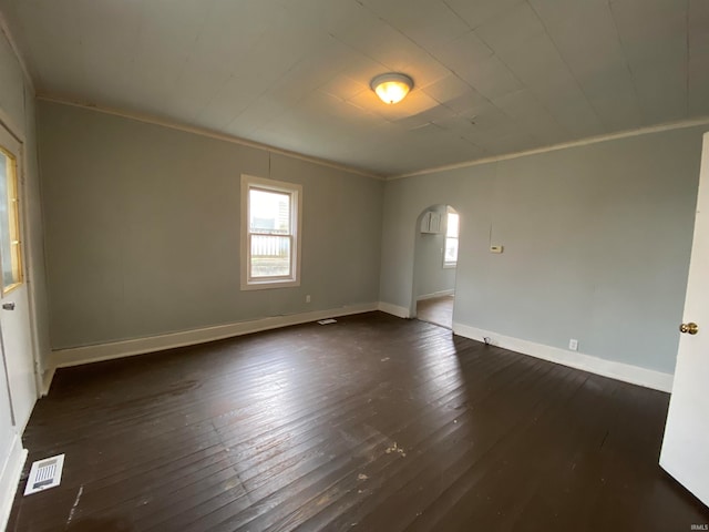 empty room featuring crown molding and dark wood-type flooring