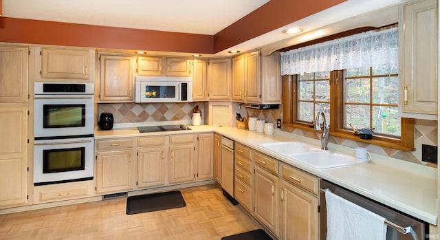 kitchen featuring decorative backsplash, white appliances, light parquet floors, and sink